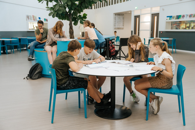Leerlingen werken en kletsen in de aula